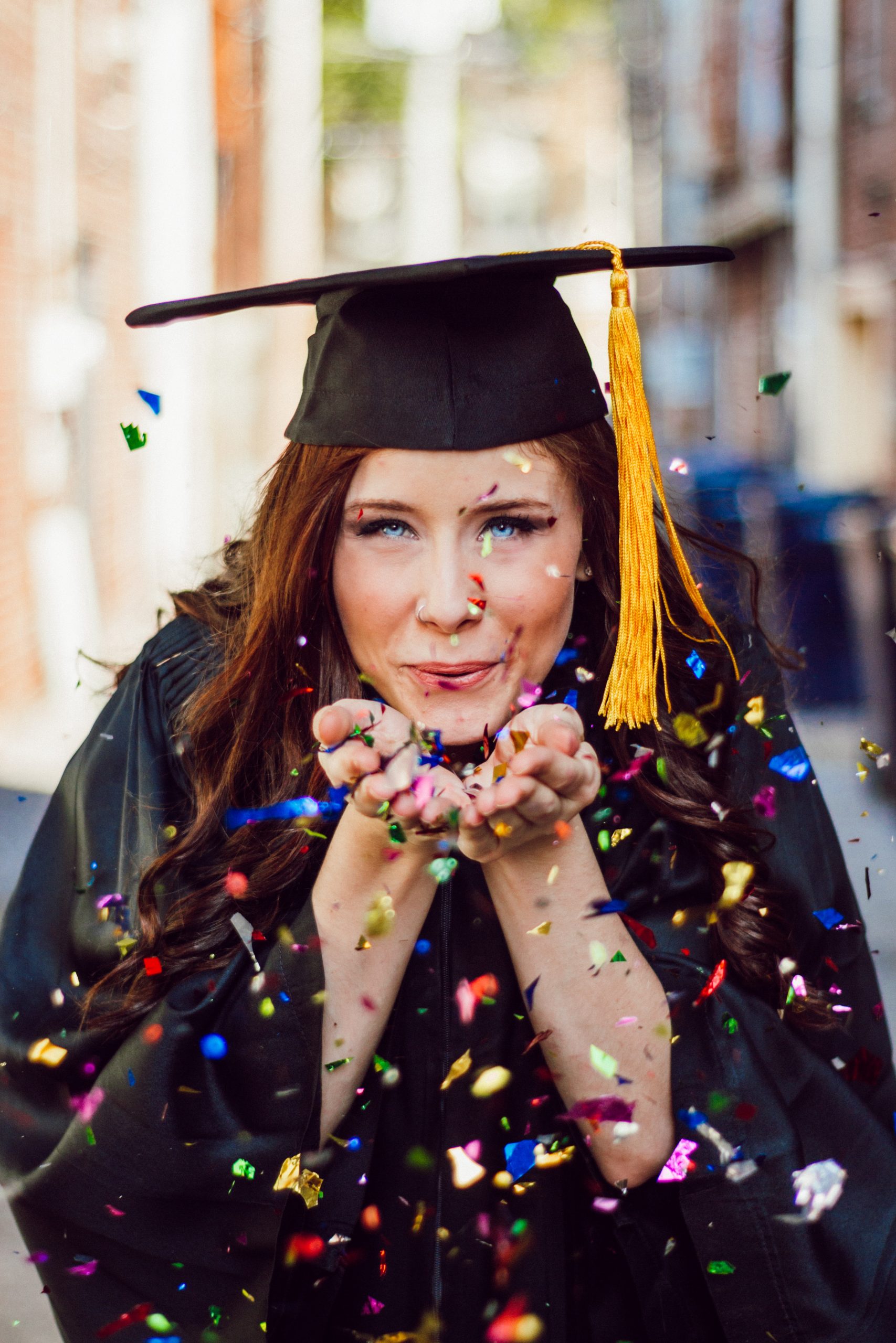 Mujer celebrando su graduación soplando confeti