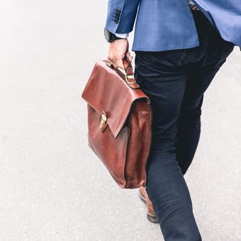 Profesor de inglés con maletin de camino a la clase